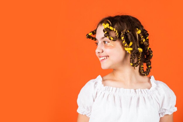 Adorável penteado infantil Rotina de beleza feminina Dicas de estilo Hobbies adolescentes Penteado Linda garota ondulando o cabelo usando bobes Filha com bobes na cabeça rindo Salão de cabeleireiro