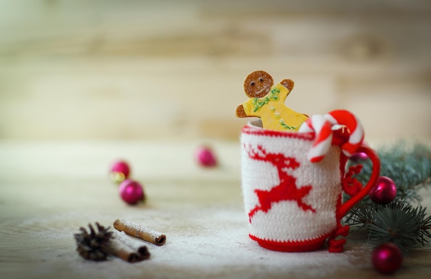 Adorno de copa de Navidad y un divertido pan de jengibre en una mesa de madera