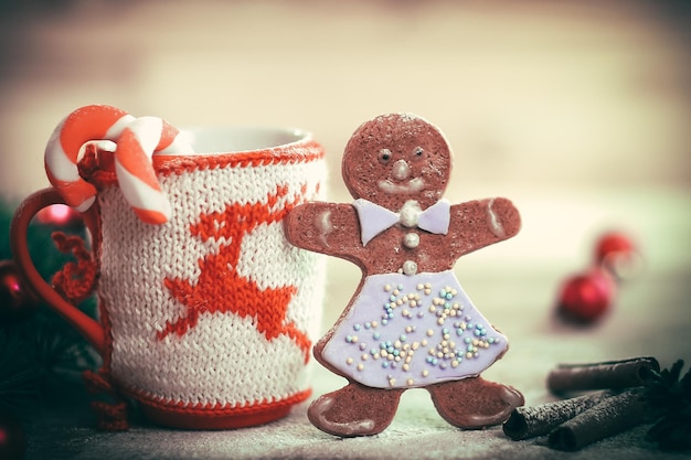 Adorno de copa de Navidad y un divertido pan de jengibre en una mesa de madera