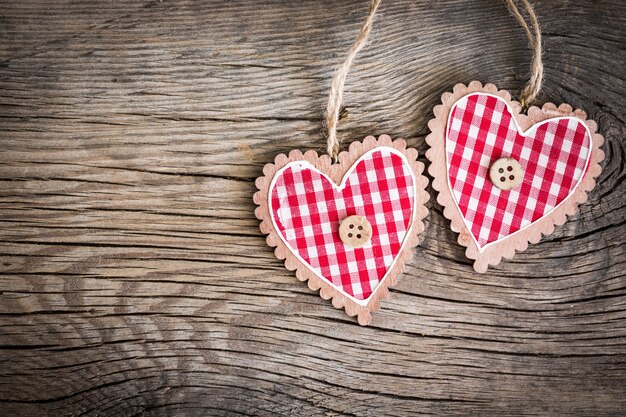 Adorno del día de San Valentín. Corazones rojos sobre fondo de madera. Tarjeta de felicitación en blanco