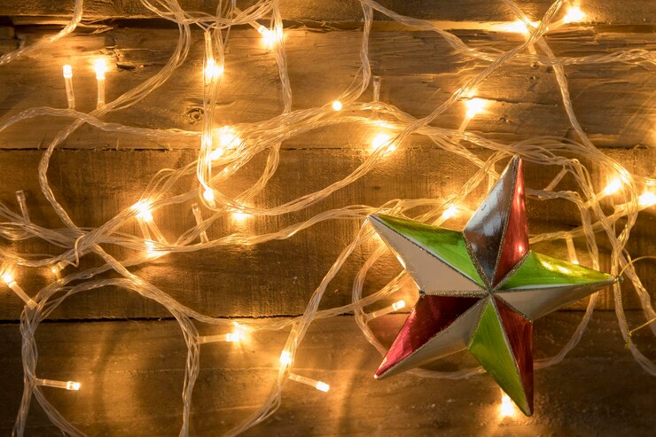 Foto adorno de estrella de navidad con luces navideñas sobre fondo de madera vintage