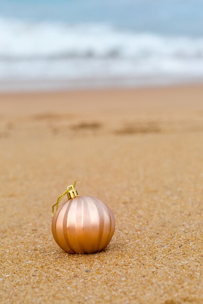 Adorno de Navidad en una playa de arena junto al mar