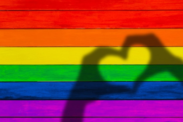 Foto adornos en colores del arco iris fondo de madera colorida bandera gay