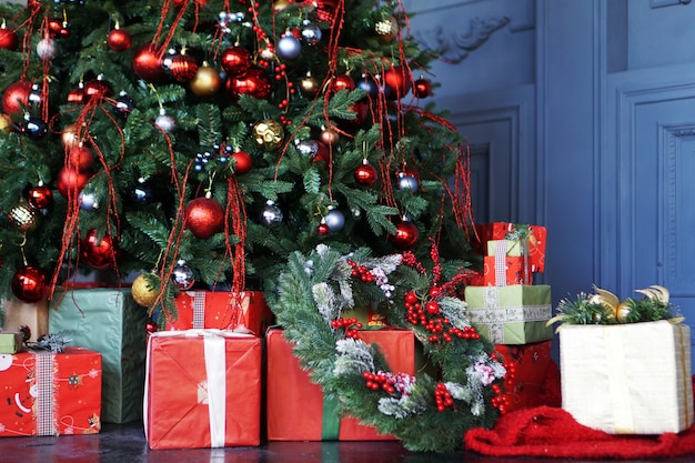 Adornos navideños, árbol de Navidad con bolas de colores y regalos.