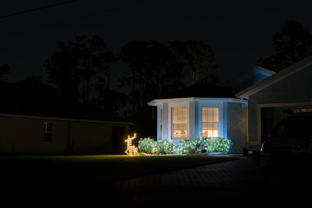 Adornos navideños brillantemente iluminados en el patio delantero de la casa familiar de florida Decoración exterior para las vacaciones de invierno