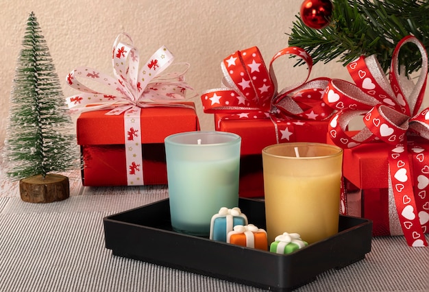 Adornos navideños con cajas de regalo y velas aromáticas.