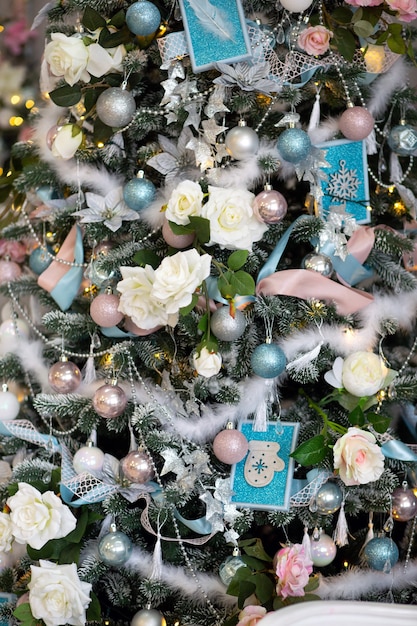 Adornos navideños en colores pastel, flores decorativas, en un árbol de año nuevo