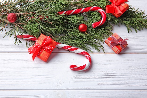 Adornos navideños y dulces sobre fondo blanco de madera