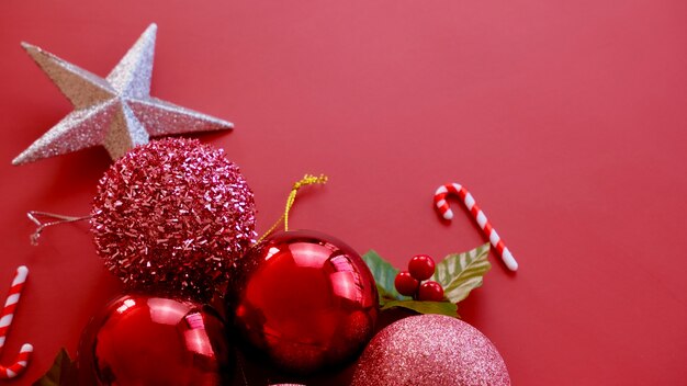 Foto adornos navideños, estrellas brillantes, bolas rojas, copos de nieve sobre fondo rojo.