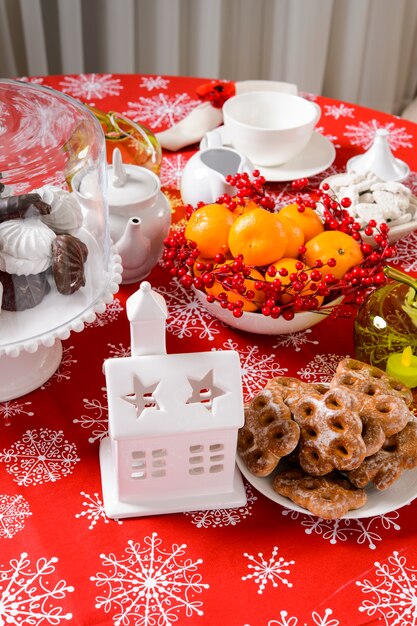 Adornos navideños en mesa con cítricos y galletas de rosa mosqueta en mesa festiva