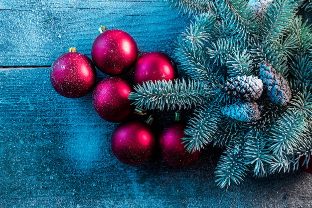 Adornos navideños en la nieve con árbol de Navidad y piñas en una mesa