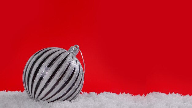 Adornos navideños en la nieve con fondo rojo copia espacioConcepto de Navidad