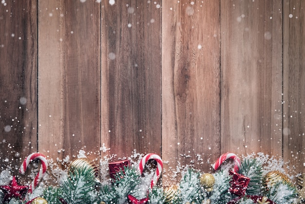 Foto adornos navideños con nieve sobre fondo de madera