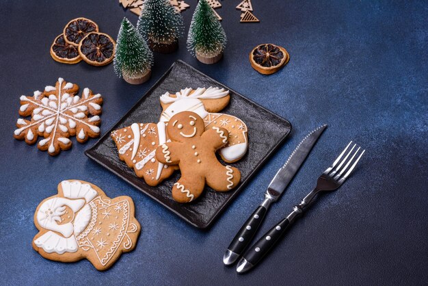 Adornos navideños y panes de jengibre en una mesa de hormigón oscuro Preparándose para la celebración