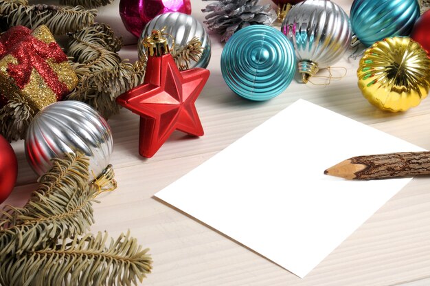 Adornos navideños con un papel vacío.