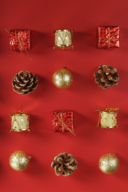 Adornos navideños en el patrón del árbol de Navidad sobre un fondo rojo.