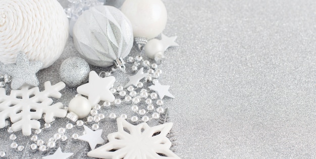 Foto adornos navideños de plata sobre una mesa plateada