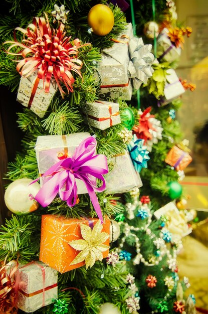 Adornos navideños en las ramas de abeto con bolas brillantes y cajas decorativas, fondo de vacaciones