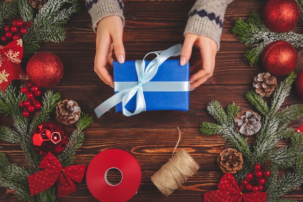 Adornos navideños y regalo sobre fondo de madera