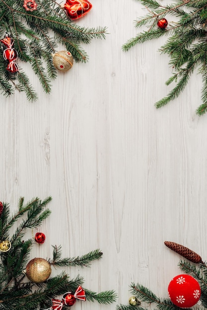 Adornos navideños rojos sobre una mesa de madera blanca con espacio de copia