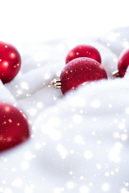 Adornos navideños rojos sobre piel esponjosa con fondo de diseño de vacaciones de invierno de lujo con brillo de nieve