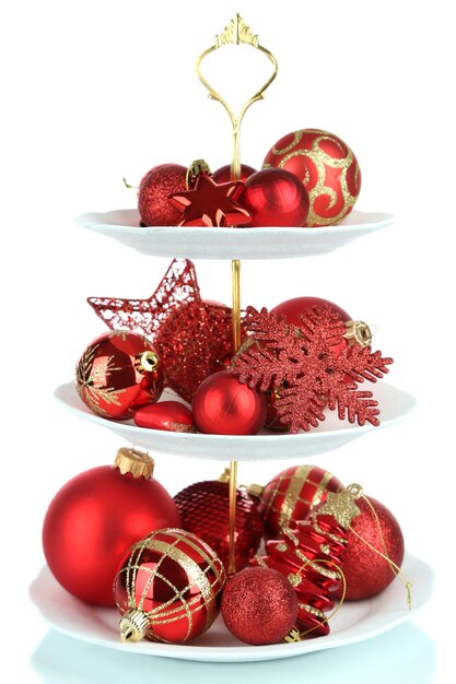 Adornos navideños en el soporte de postres, aislado en blanco