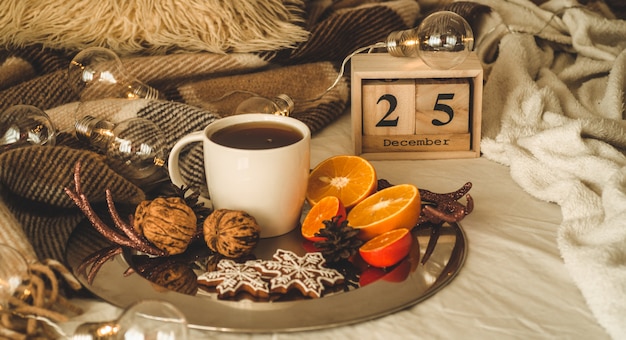 Adornos navideños con taza de té, pan de jengibre y naranjas