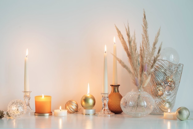 Adornos navideños con velas encendidas en la sala blanca