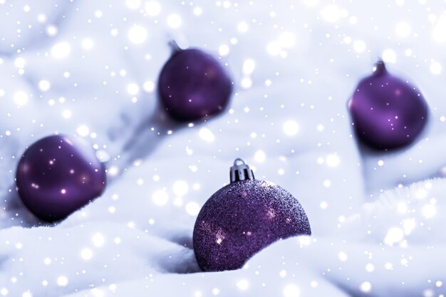 Adornos navideños violetas en piel esponjosa con fondo de diseño de vacaciones de invierno de lujo con brillo de nieve