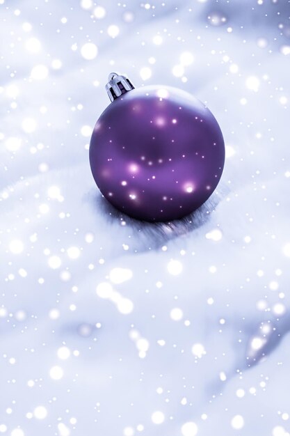 Adornos navideños violetas en piel esponjosa con fondo de diseño de vacaciones de invierno de lujo con brillo de nieve