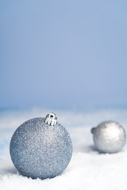 Adornos navideños en la vista lateral de nieve. Tonos gris azulados. Fondo para feliz año nuevo y saludos navideños