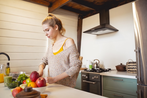 Adoro cozinhar. Linda mulher olhando para baixo enquanto passa um tempo na cozinha