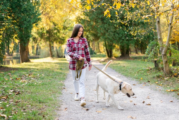 Foto adulta mulher caminhando no parque com seu cachorro