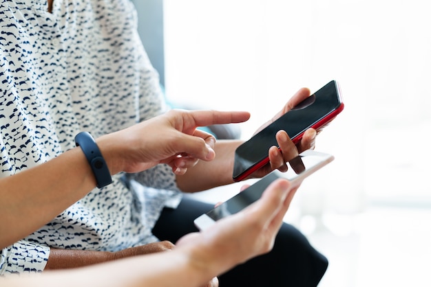 Adulta mulher e filha usando smartphone com tela em branco