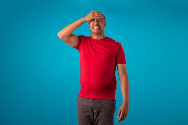 Adulto en camisa roja sobre fondo azul, realizando diversas expresiones faciales.