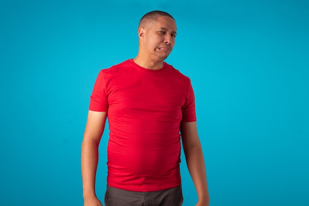 Foto adulto de camisa vermelha sobre fundo azul, fazendo várias expressões faciais.