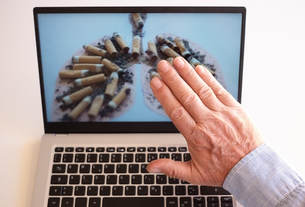 Adulto entrega el teclado de la computadora portátil listo para dejar de fumar Día mundial de la tuberculosis Día mundial sin tabaco corona virus covid19 contaminación biológica del aire concepto de donación de órganos