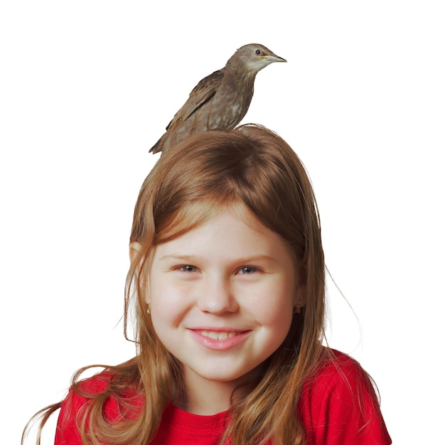 Adulto estornino enclavado sentado en la cabeza de una niña alegre Retrato de un niño sonriente aislado en blanco