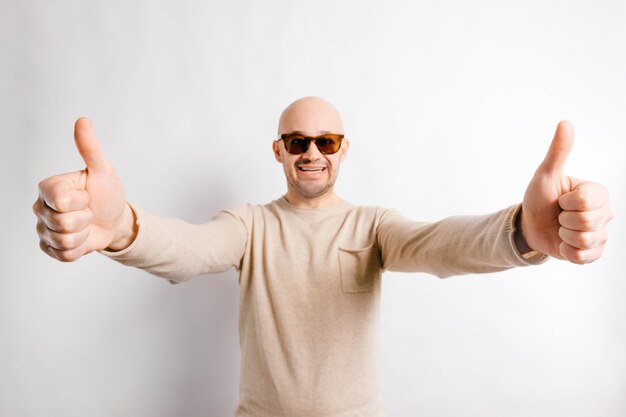 Adulto feliz empresário em óculos de sol, mostrando os polegares.