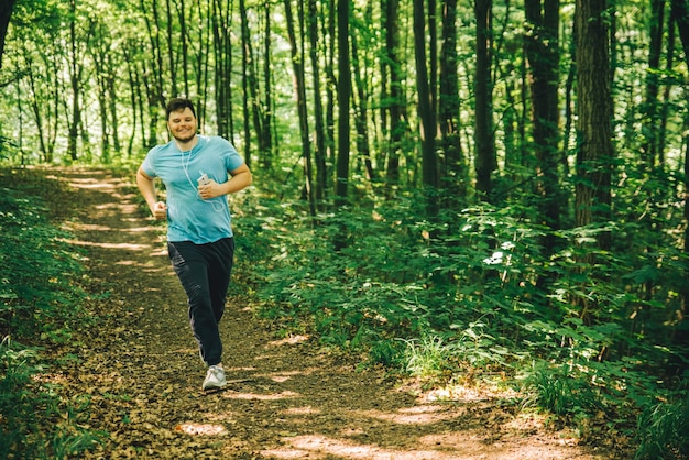 Adulto joven corriendo en el bosque copia espacio sonriendo