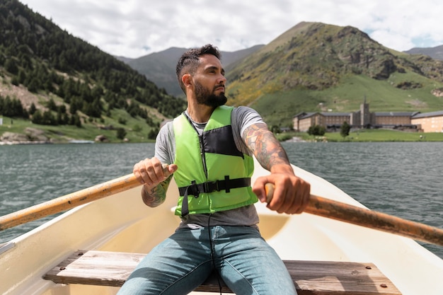 Foto adulto joven disfrutando de kayak canoa en el río