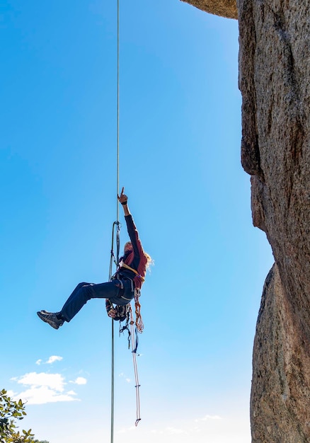 Adulto joven escalador rapelando una pared de granito en Torrelodones Madrid Concepto de deportes extremos