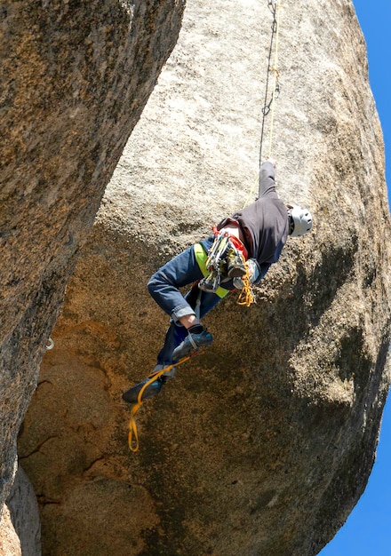 Adulto joven escalando un voladizo de granito en Torrelodones Madrid Escalada en roca Concepto de deportes extremos