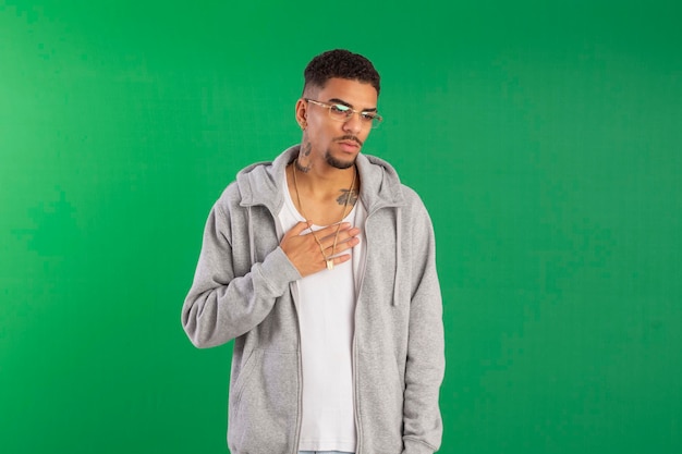 Adulto joven estilo hip hop en foto de estudio con fondo verde ideal para recortar