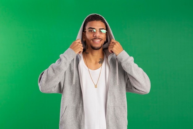 Adulto joven estilo hip hop en foto de estudio con fondo verde ideal para recortar