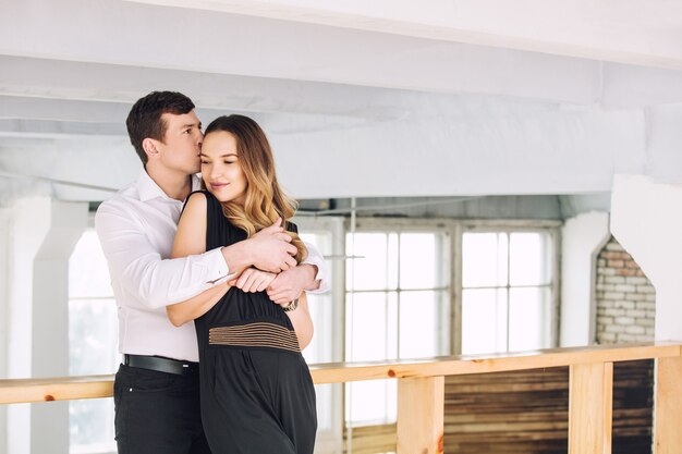 Adulto joven hermosa pareja hombre y mujer felices juntos en el interior de estilo loft