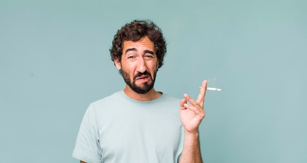 Adulto joven hispano loco con un cigarrillo