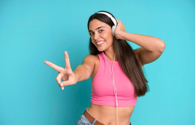 Foto adulto joven hispano y mujer expresiva escuchando música y bailando con auriculares