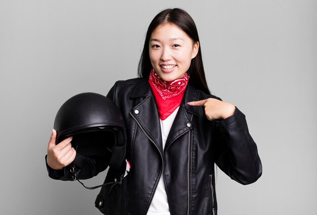 Adulto joven mujer bastante asiática motociclista con chaqueta de cuero y concepto de casco