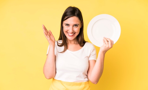 Adulto joven mujer bonita chef casero con plato vacío